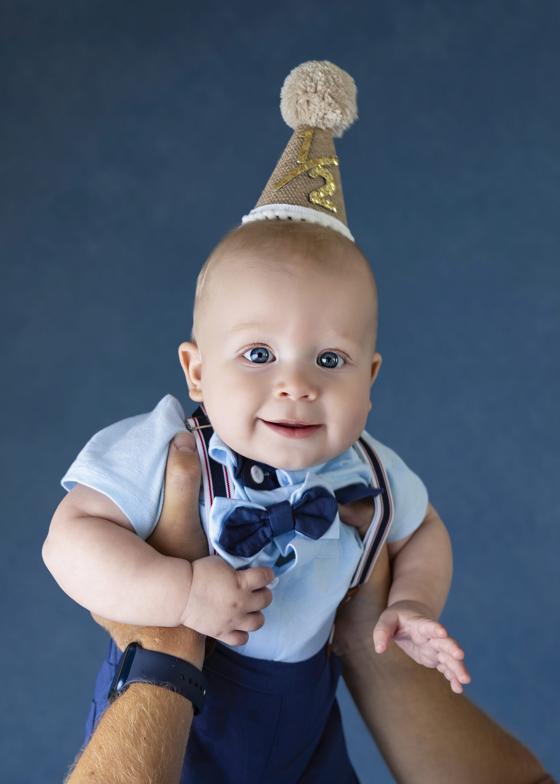 Baby boy wearing a blue bow tie and birthday hat during a milestone photography session in San Ramon, CA | FrameIt Bay Area.