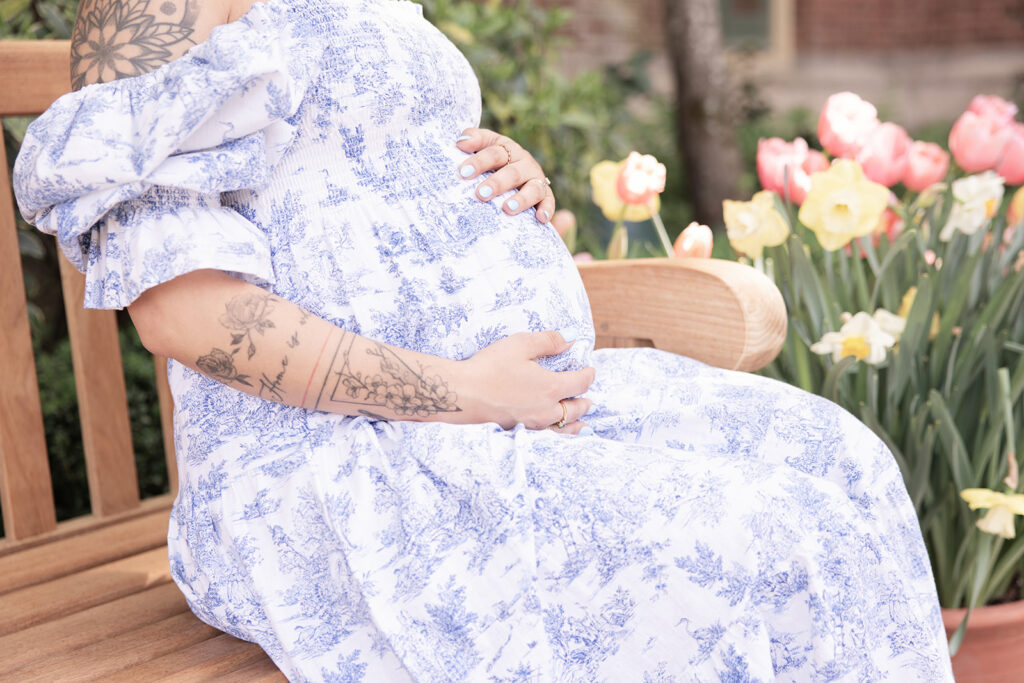lose-up of pregnant belly and blue floral maternity dress during an outdoor maternity photoshoot at Filoli Garden