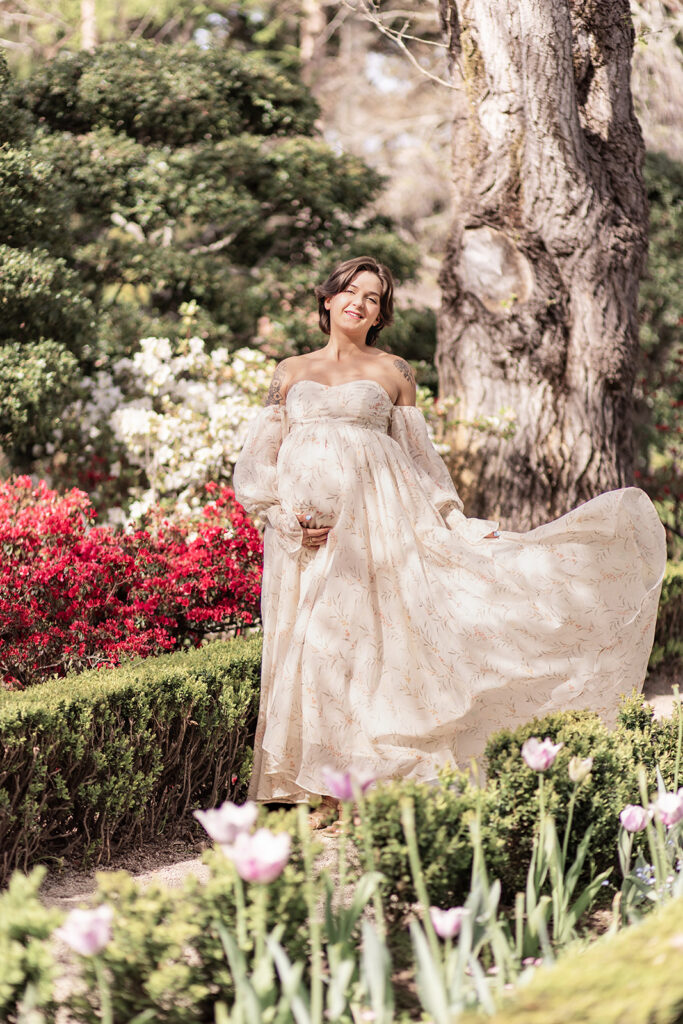 Expectant mother in elegant white maternity dress during a Bay Area maternity photoshoot at Filoli Garden