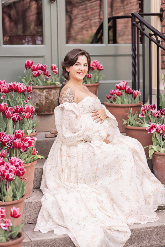 Expectant mother in white maternity dress posing at Filoli Garden during an outdoor maternity photoshoot