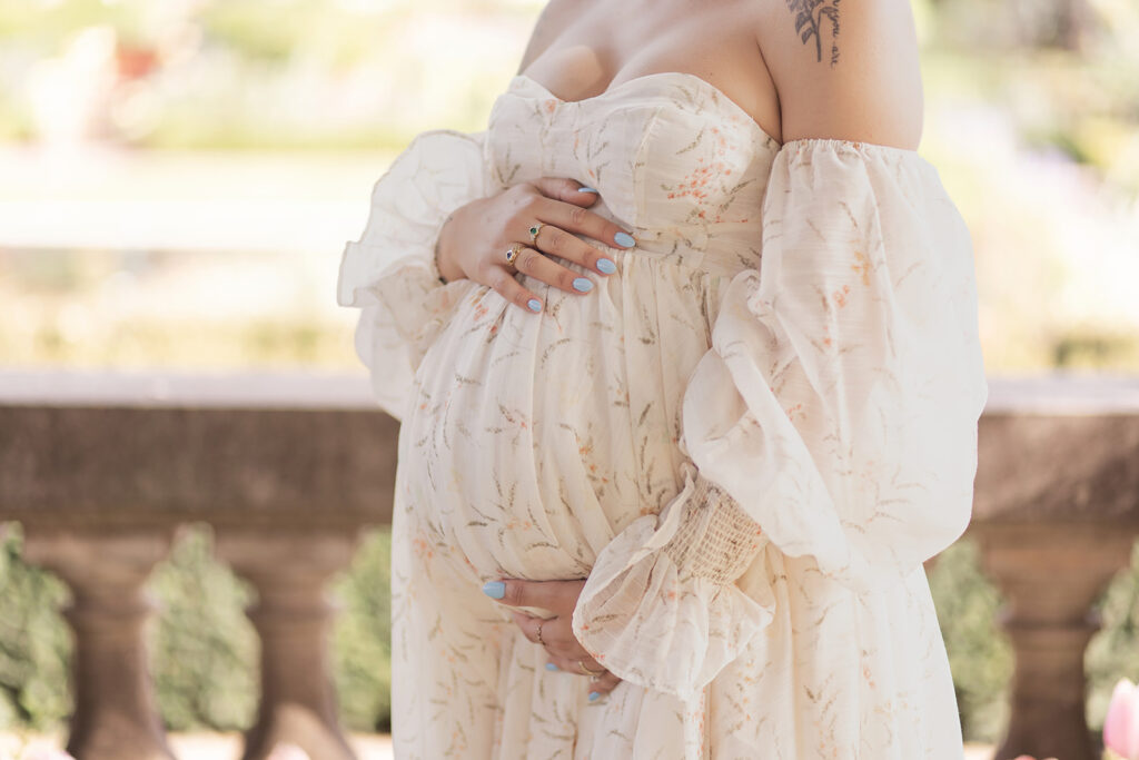Pregnant woman with hands on belly during an outdoor maternity photoshoot at Filoli Garden
