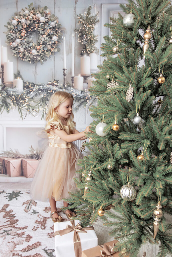 Young girl standing beside a decorated Christmas tree during a Christmas photography session in San Ramon