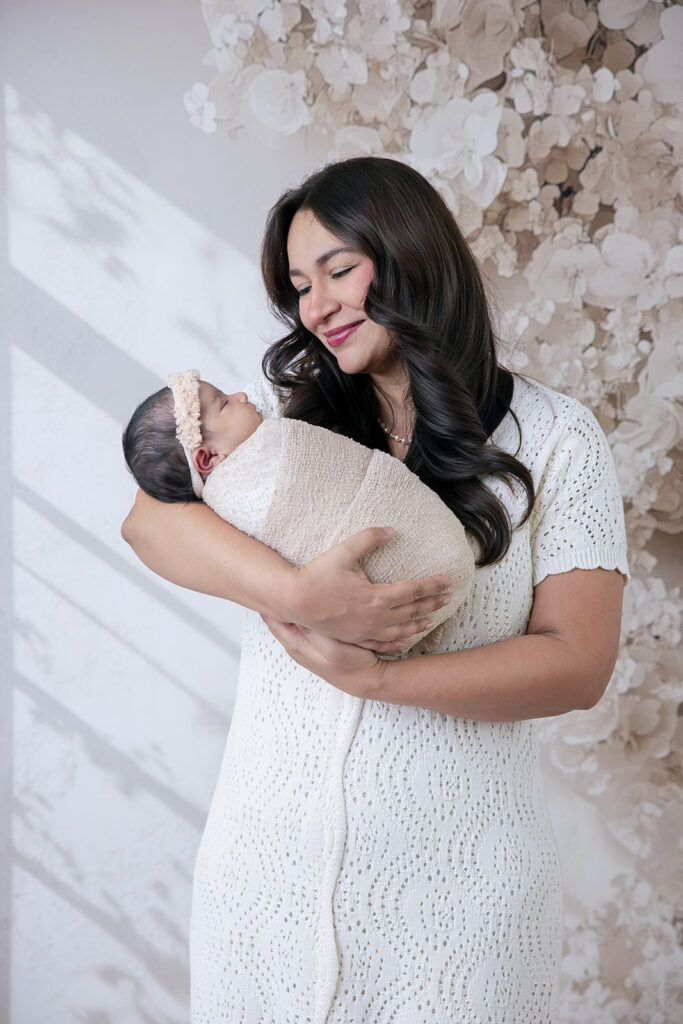 Mother holding her newborn baby during matrescence, the transition into motherhood.