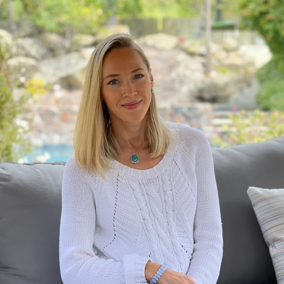 Portrait of Anna, photographer and founder of FrameIt Bay Area, smiling outdoors in a white sweater.