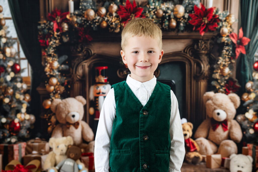 Young boy posing by a Christmas fireplace during a holiday mini session in Danville