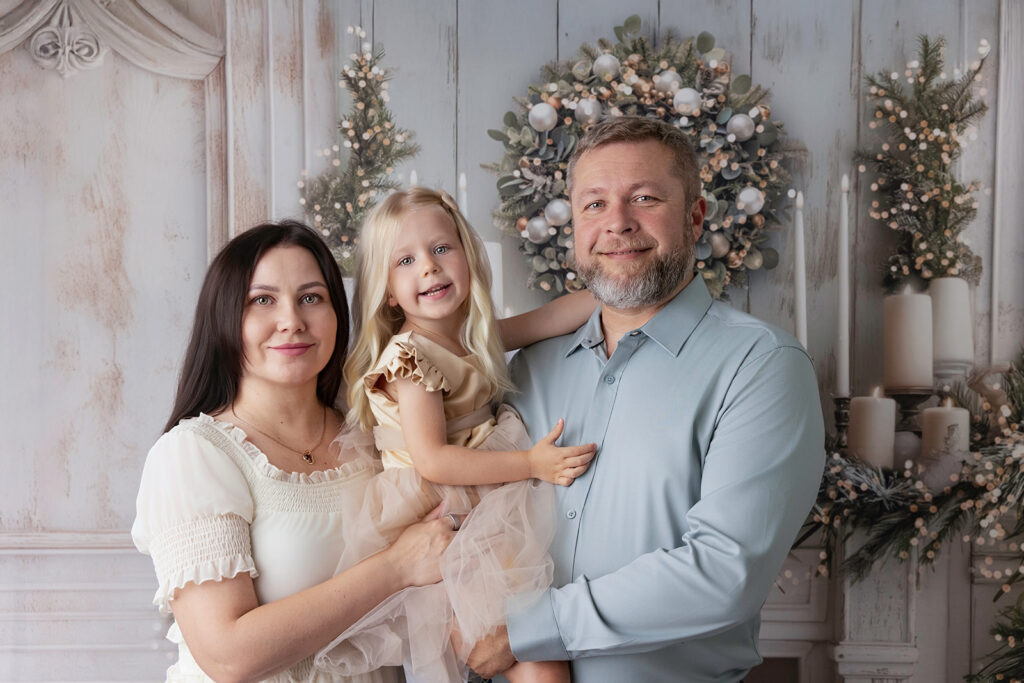 Alamo Christmas family photos of parents and daughter together in an elegant holiday setting with a decorated Christmas tree