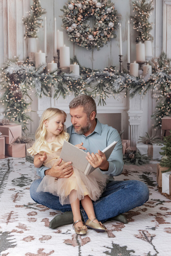 East Bay Christmas family photos of a father and daughter sharing a cozy moment by a festive holiday fireplace