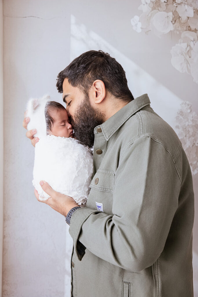 Father holding his newborn baby close during an East Bay newborn photography session.