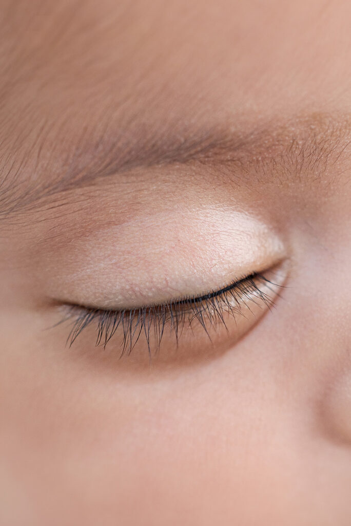 Close-up of a newborn baby’s closed eye and delicate eyelashes, photographed in a San Ramon newborn photography studio.