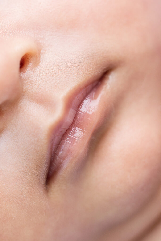 Close-up of a sleeping newborn baby’s delicate lips and nose in a studio newborn portrait.