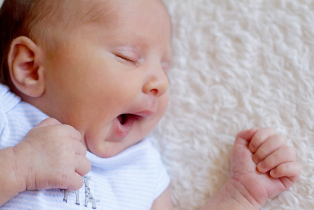 Newborn baby yawning during a professional newborn photography session