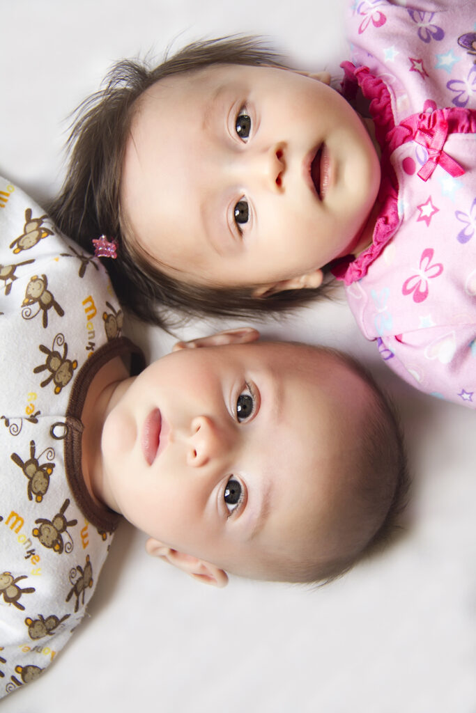 Twin babies photographed together during a newborn photography session at FrameIt Bay Area